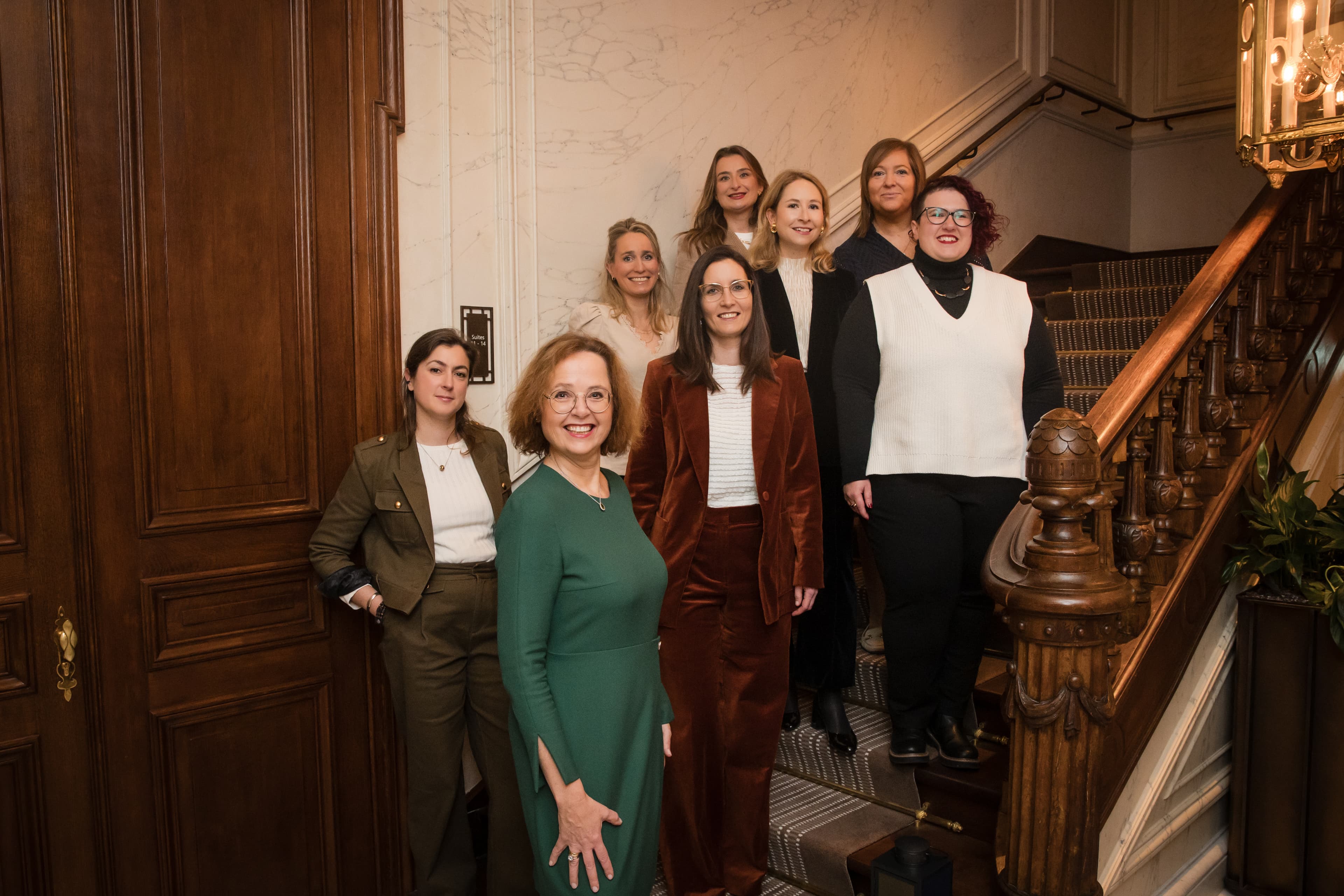 The Luxembourg Convention Bureau team posing on an elegant wooden staircase